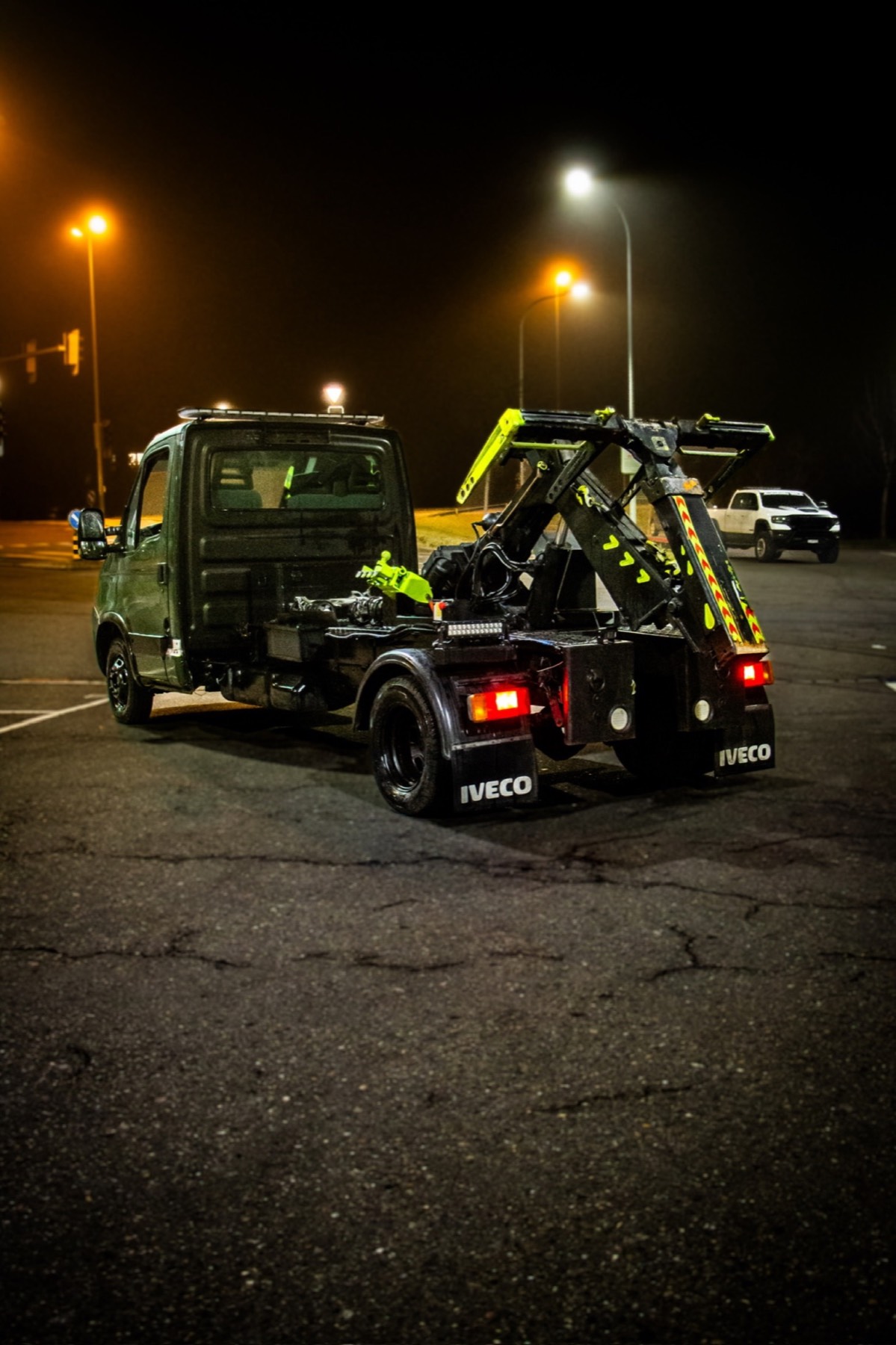 Iveco Daily mit ausgefahrener Hubbrille von Autohilfe MILA in nächtlicher Heckansicht