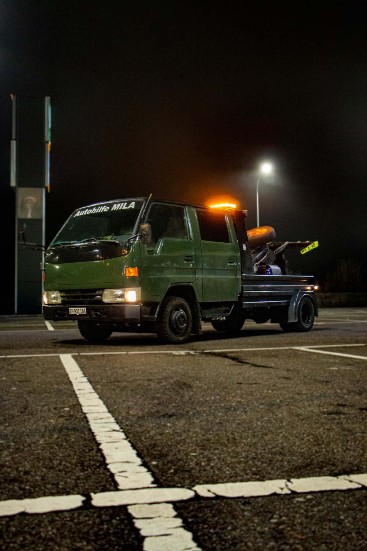 Toyota Dyna Langversion von Autohilfe MILA mit eingeschaltetem Warnlicht in seitlicher Frontansicht