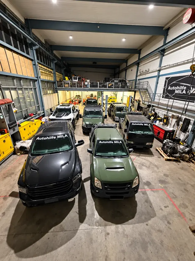 Mehrere Einsatzfahrzeuge von Autohilfe MILA in der Werkstatthalle